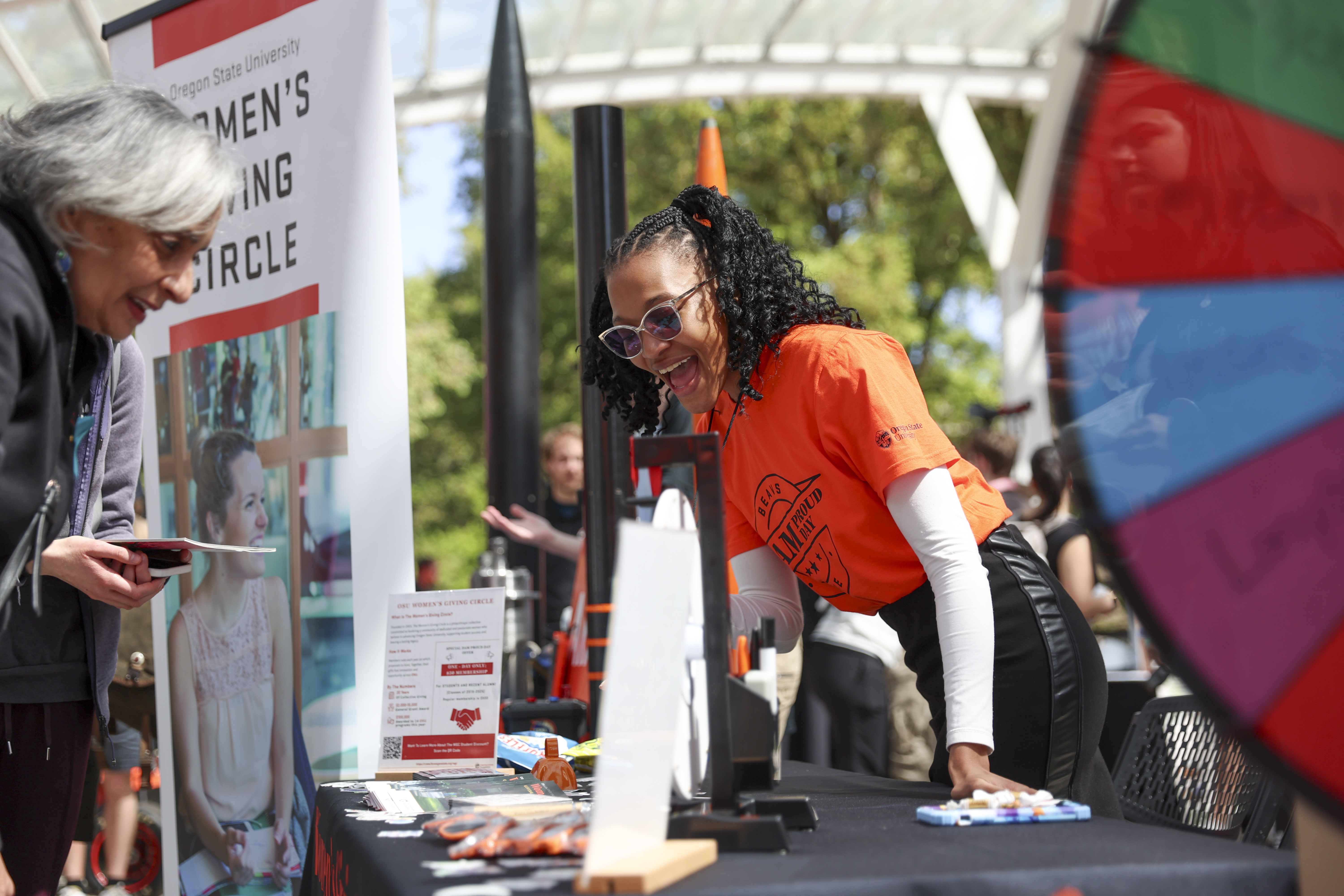 Two women interacting at the Women's Giving Circle table during Dam Proud Day