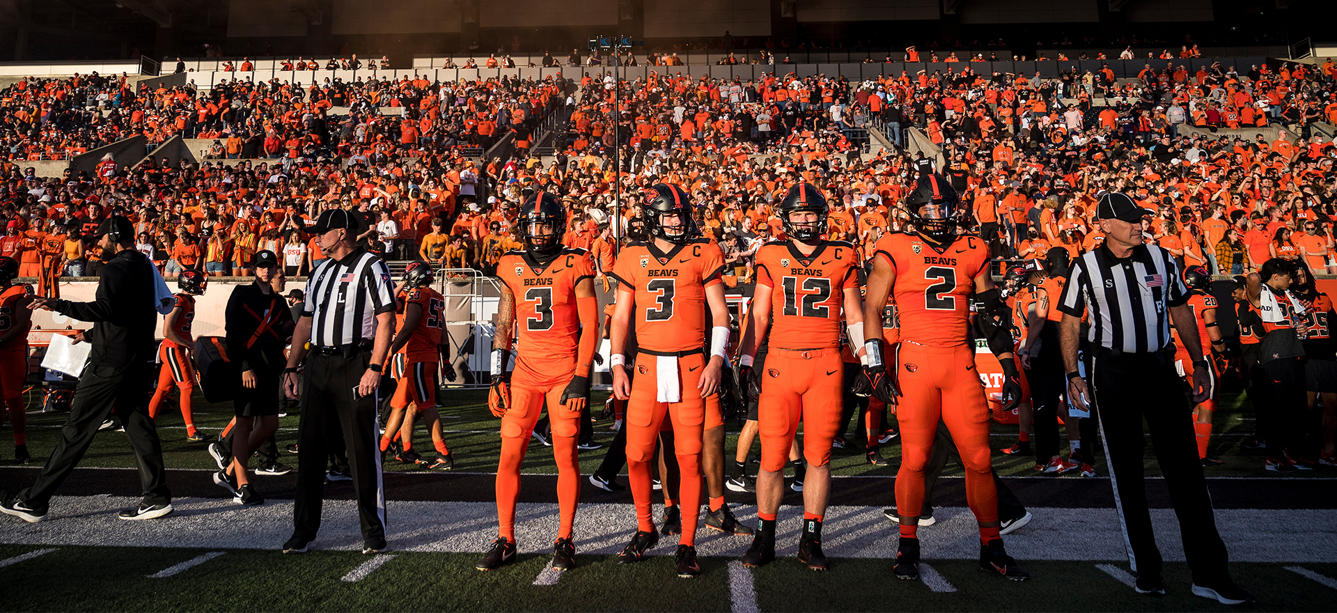 OSU Beaver Football players lined up in a row on the sideline