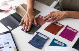 389902044-osudn_may17_sf-eventthumbnail person who is comparing fabric swatches for designing a new product