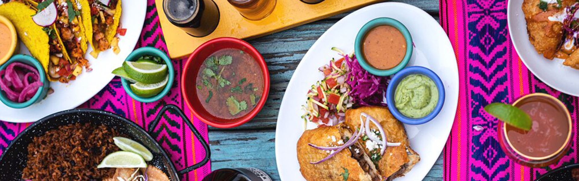 table with a colorful spread of hispanic food, photo by Joel Bahena