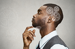 a man in deep thought looking to the side, with gears photoshopped on top of his head