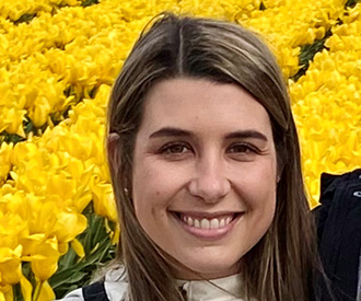 Headshot of Ally Rumpakis with yellow flowers in the background