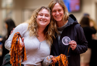 An OSU mom and their kid smiling at the camera.