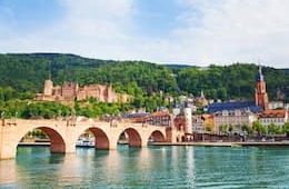 Alte Brucke bridge with river and historic buildings and mountains in the background