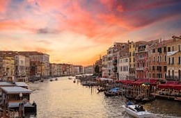 Venice at sunset with canal and buildings lining the water