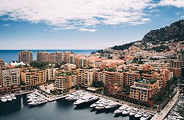 MonteCarlo view of docks with yachts and ocean with buildings on the hiillside