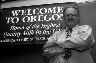 Professor Floyd Bodyfelt standing behind sign reading 