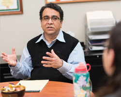 Sunil Khanna speaking with other proffesionals at a table