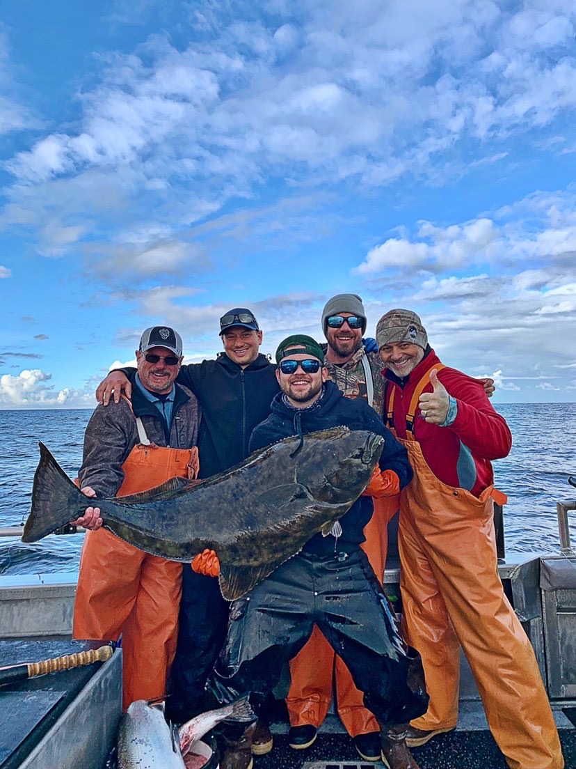 Mike Allen holding a large fish with fishermen side by side