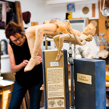 Photo of sculptor Ellen Tykeson working on sculpture of Dick Fosbury