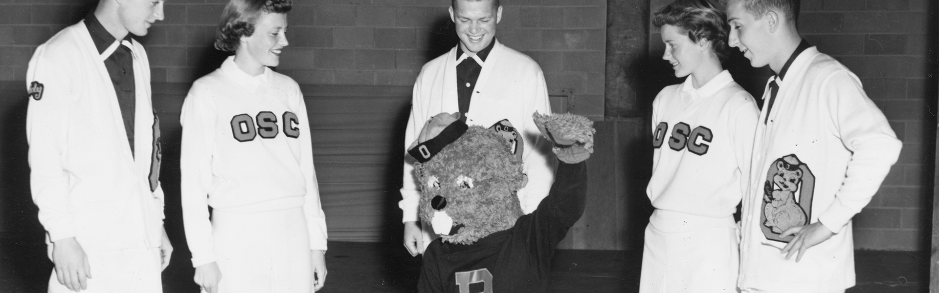1952 black and white photo of Benny and cheer leaders.