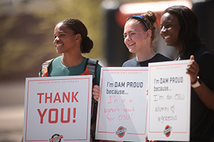 Photo of students holding signs on Dam Proud Day