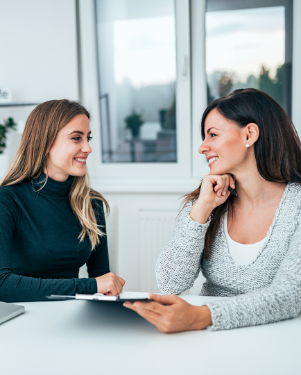 Two smiling women at a desk