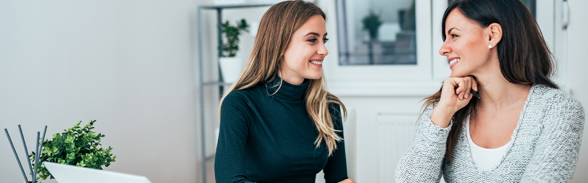 Two smiling women at a desk