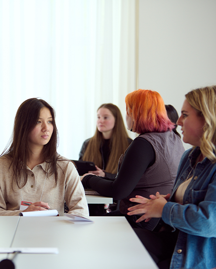 Alumni and students talking around a table at a mentoring event.