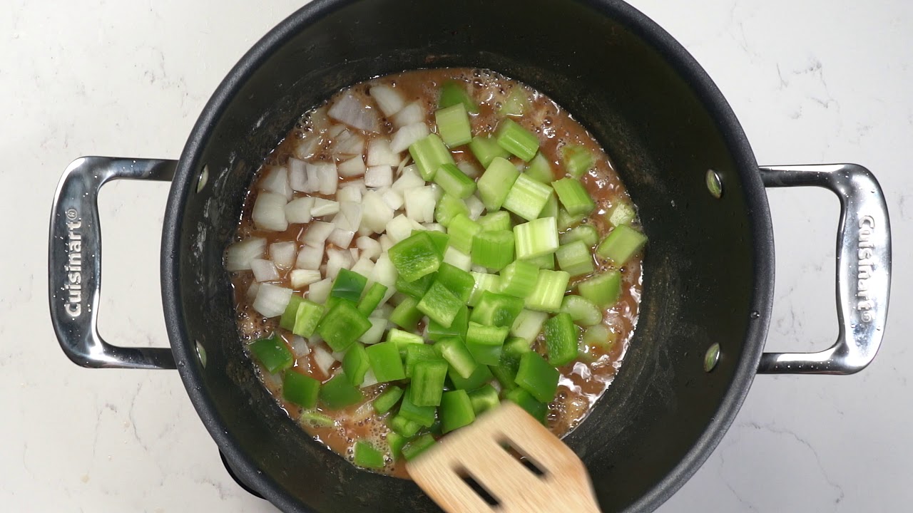 Duck Gumbo seen with fresh celery and onions in a large pot bird's eye view